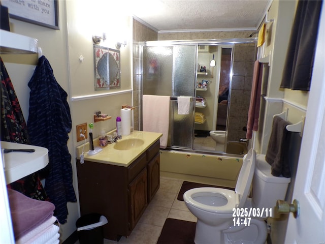 bathroom featuring toilet, a textured ceiling, tile patterned flooring, bath / shower combo with glass door, and vanity