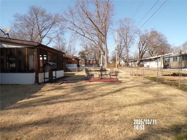 view of yard with fence and a sunroom