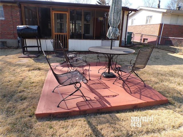 view of patio with fence and a sunroom