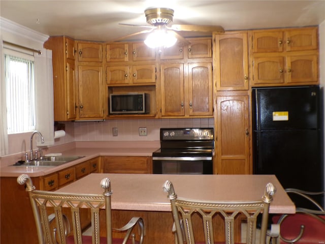 kitchen featuring a sink, light countertops, a ceiling fan, backsplash, and black appliances