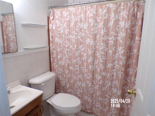 full bathroom with toilet, tile walls, and vanity