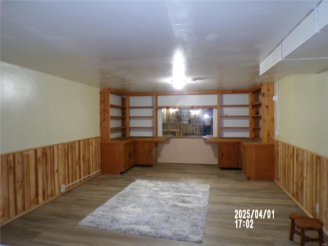 finished below grade area with wood walls, wainscoting, and wood finished floors