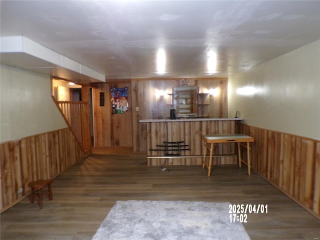 bar with wood walls, wood finished floors, and a wainscoted wall