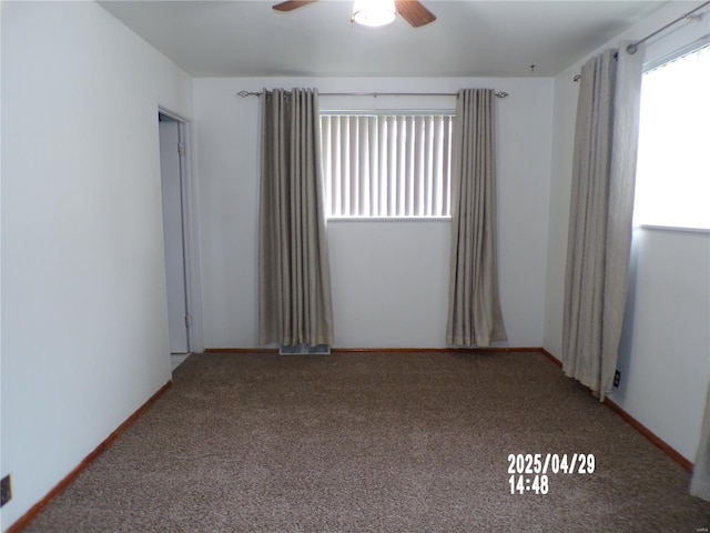 carpeted spare room with a ceiling fan