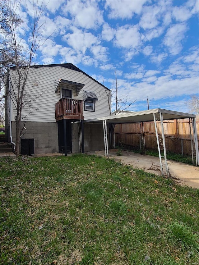 back of house featuring concrete driveway, a yard, and fence