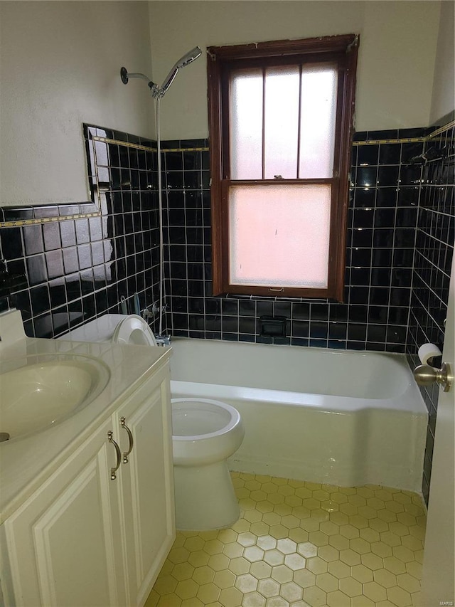 bathroom featuring toilet, tile walls, wainscoting,  shower combination, and vanity