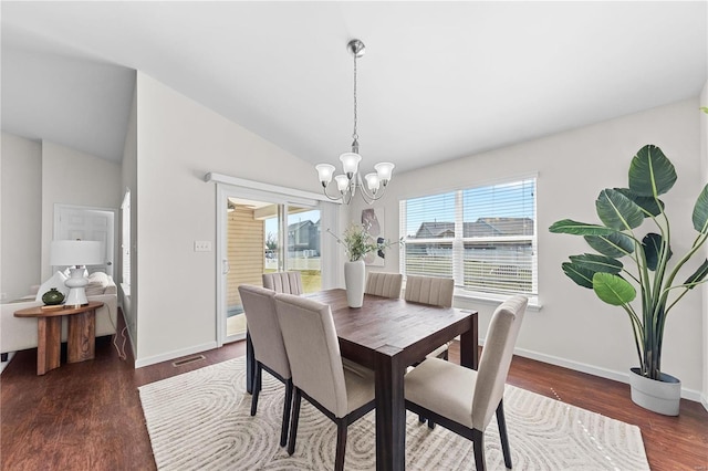 dining room with a notable chandelier, baseboards, lofted ceiling, and wood finished floors