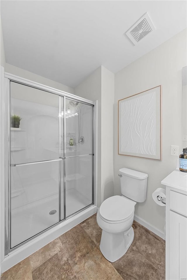 bathroom featuring visible vents, vanity, a shower stall, and toilet