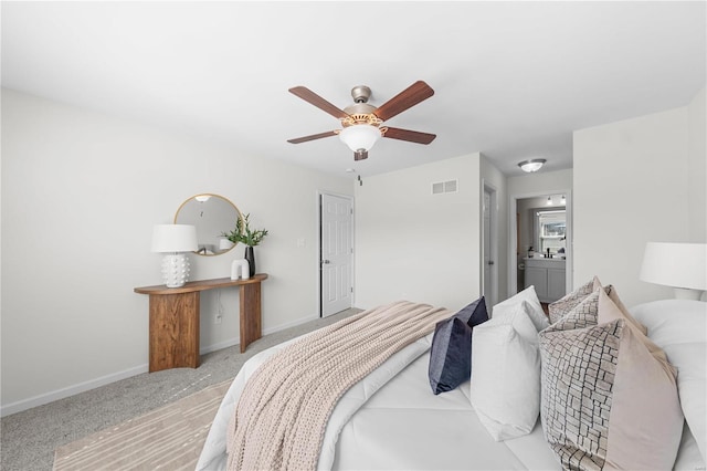 bedroom with visible vents, ensuite bathroom, carpet floors, baseboards, and ceiling fan