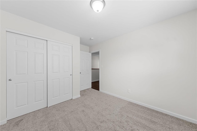 unfurnished bedroom featuring a closet, baseboards, and carpet floors