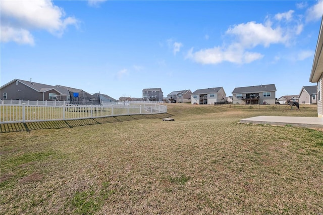 view of yard featuring fence and a residential view