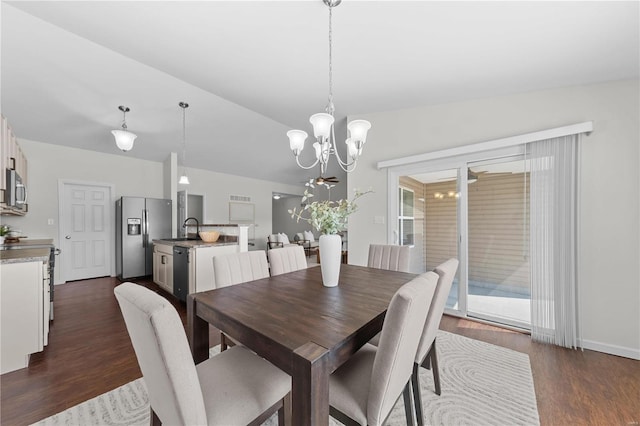 dining space with an inviting chandelier, vaulted ceiling, and dark wood-style floors