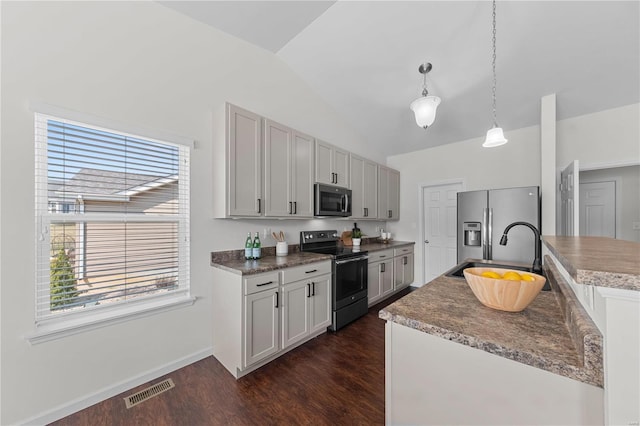 kitchen with visible vents, dark wood-style flooring, a sink, vaulted ceiling, and appliances with stainless steel finishes