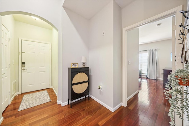 entryway with visible vents, baseboards, arched walkways, and hardwood / wood-style floors