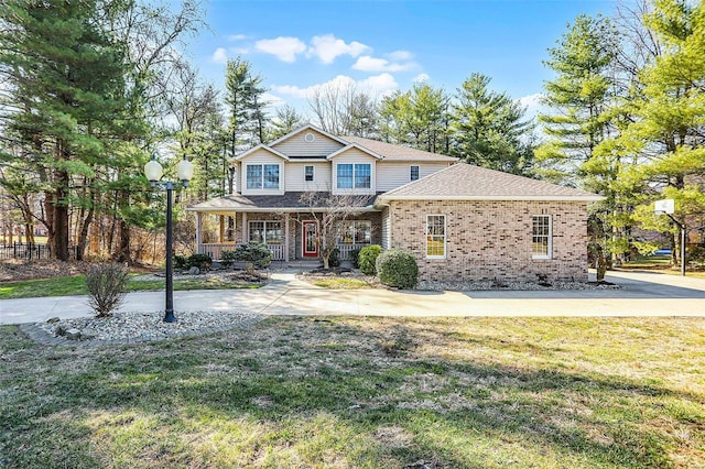 traditional-style house featuring brick siding, a porch, and a front lawn