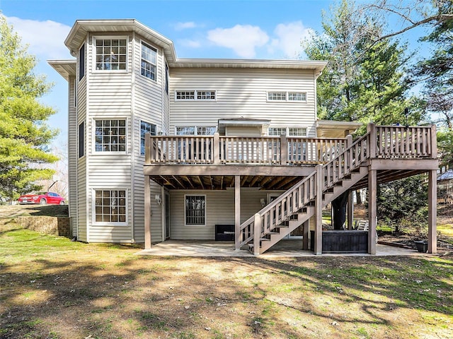 rear view of property featuring stairway, a wooden deck, and a patio