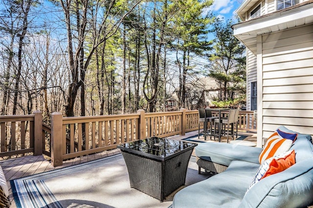 wooden terrace with an outdoor living space and outdoor dining area