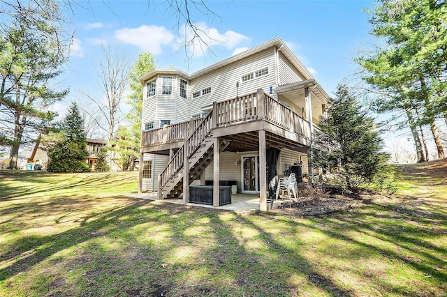 rear view of house with a patio, stairway, a wooden deck, a yard, and a jacuzzi