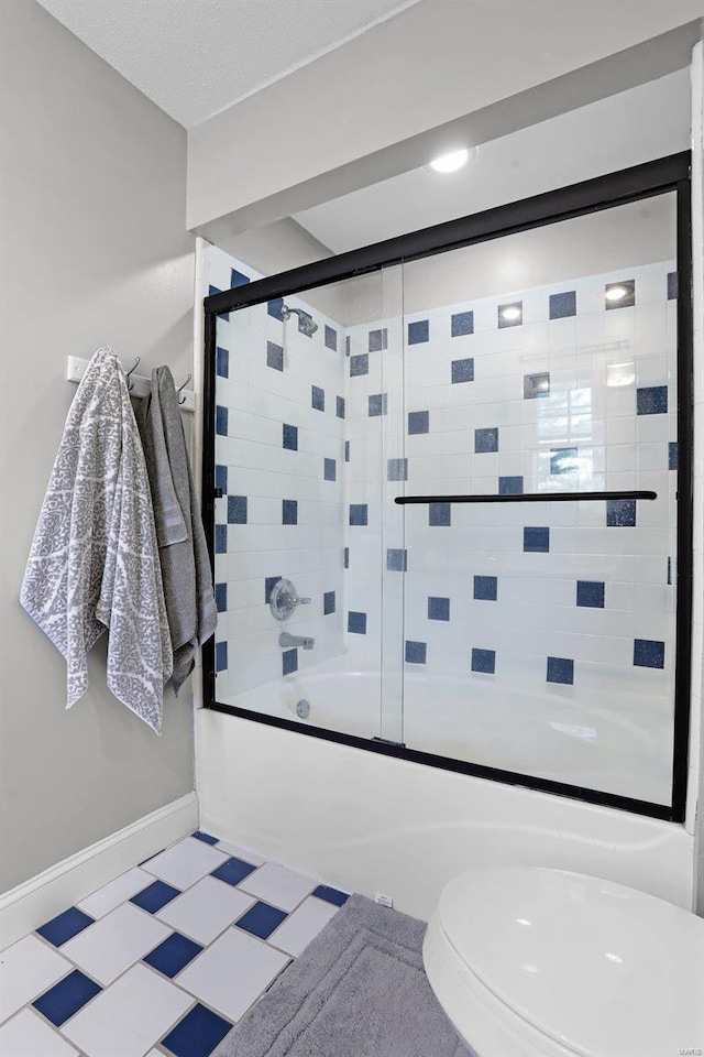 bathroom with combined bath / shower with glass door, baseboards, and toilet