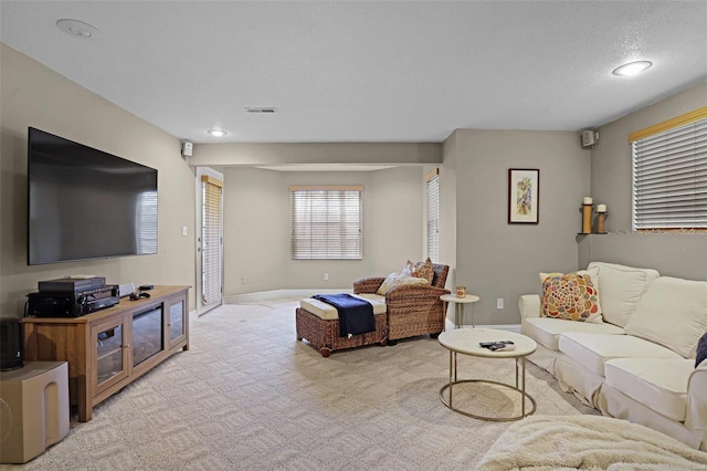 carpeted living area featuring recessed lighting and baseboards