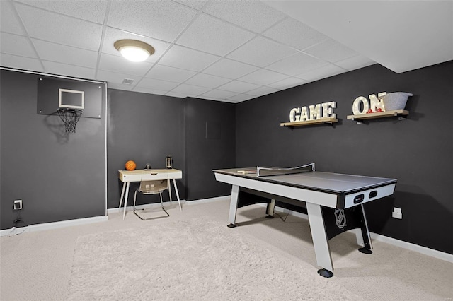 recreation room featuring baseboards, a paneled ceiling, and carpet floors