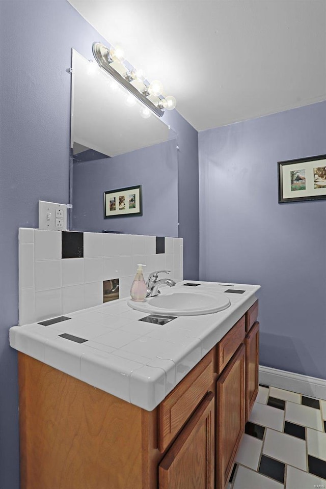 bathroom with decorative backsplash, baseboards, and a sink