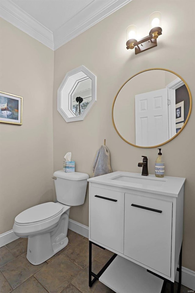 bathroom with vanity, toilet, crown molding, and baseboards