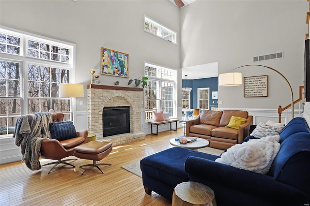 living room with visible vents, wood-type flooring, wainscoting, and a fireplace