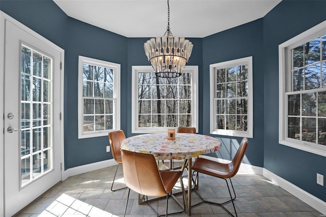 dining space with a chandelier and baseboards