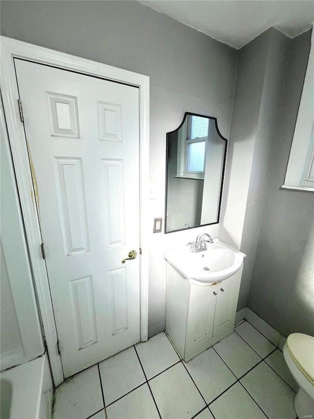 bathroom featuring vanity, tile patterned floors, toilet, and baseboards