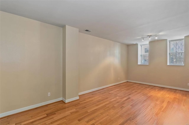 unfurnished room featuring visible vents, baseboards, and light wood-style floors