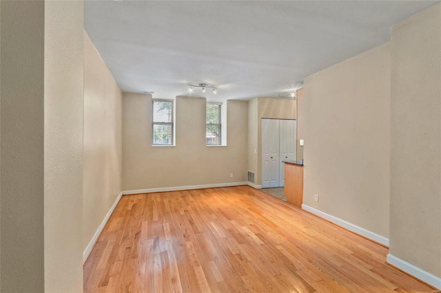 spare room with visible vents, baseboards, and light wood-style floors