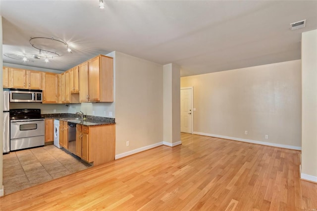 kitchen featuring visible vents, open floor plan, appliances with stainless steel finishes, light wood finished floors, and baseboards