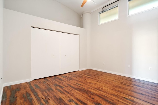 unfurnished bedroom featuring a closet, baseboards, and hardwood / wood-style flooring