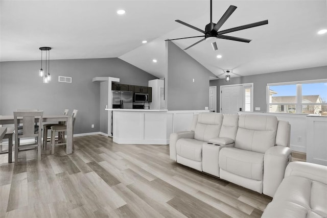 living room with visible vents, lofted ceiling, recessed lighting, light wood-style flooring, and a ceiling fan