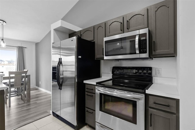 kitchen with pendant lighting, gray cabinetry, stainless steel appliances, light countertops, and light tile patterned floors