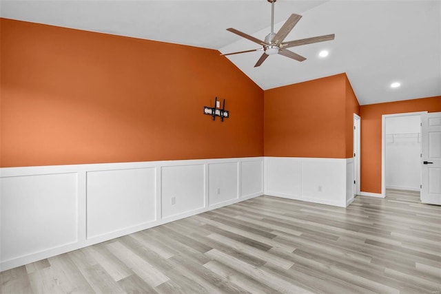 empty room with wood finished floors, recessed lighting, wainscoting, ceiling fan, and vaulted ceiling