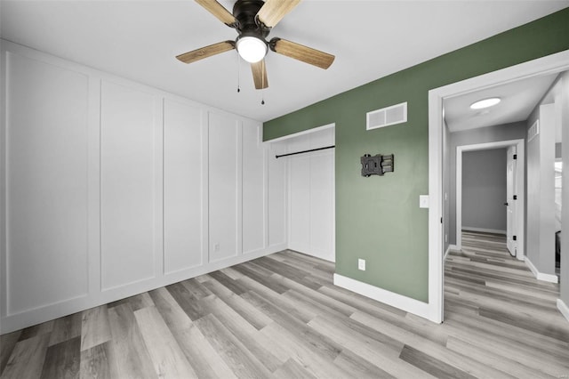 unfurnished bedroom with a ceiling fan, baseboards, visible vents, and light wood finished floors