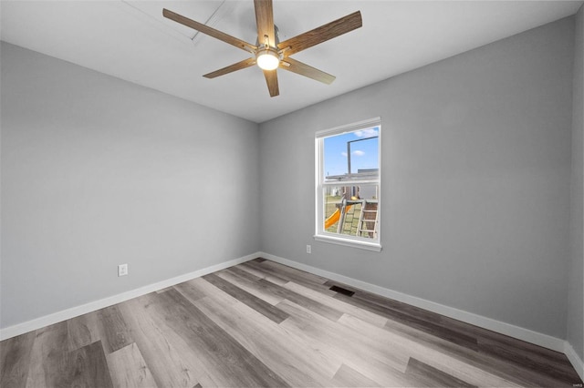 empty room with a ceiling fan, wood finished floors, baseboards, and visible vents