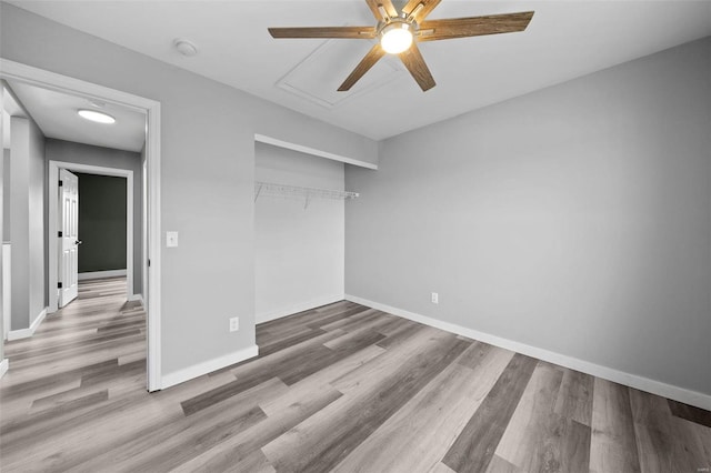 unfurnished bedroom with a closet, ceiling fan, baseboards, and wood finished floors