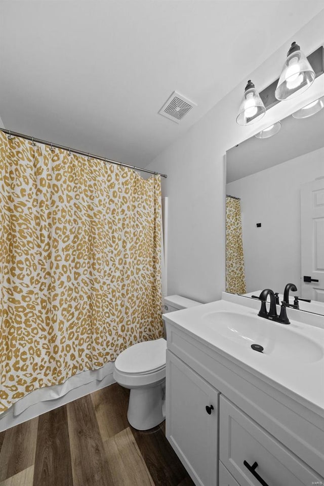 full bath featuring vanity, wood finished floors, visible vents, curtained shower, and toilet