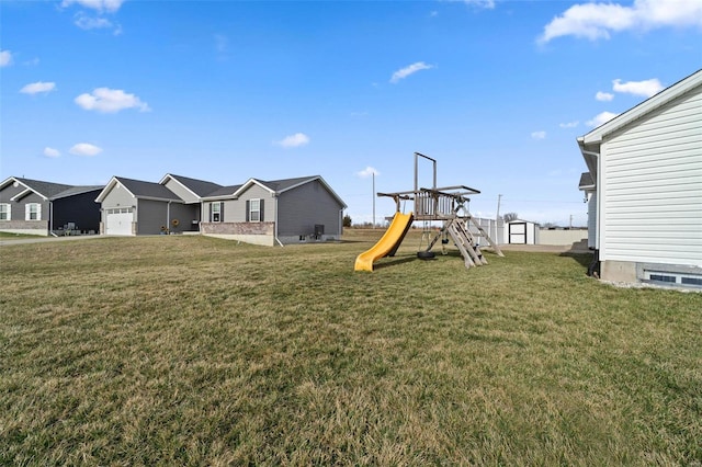 view of yard featuring an outdoor structure, a playground, and a garage