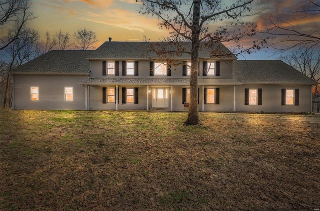 rear view of house featuring a lawn