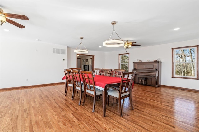 dining area featuring light wood-style flooring, baseboards, and visible vents