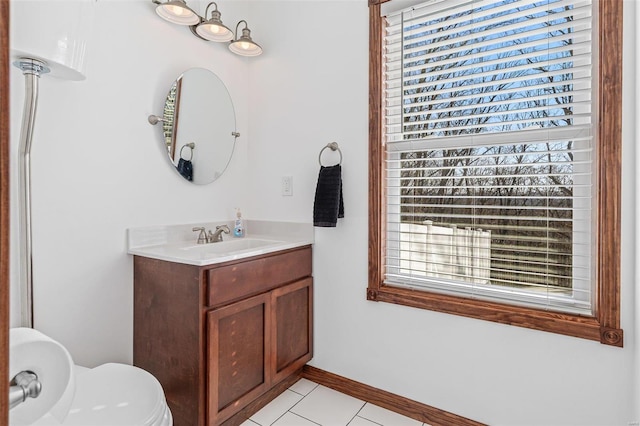 bathroom with tile patterned flooring, toilet, vanity, and baseboards