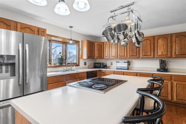 kitchen with black appliances, brown cabinets, and a sink