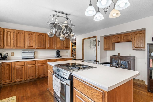 kitchen with dark wood finished floors, brown cabinets, stainless steel electric range oven, and light countertops