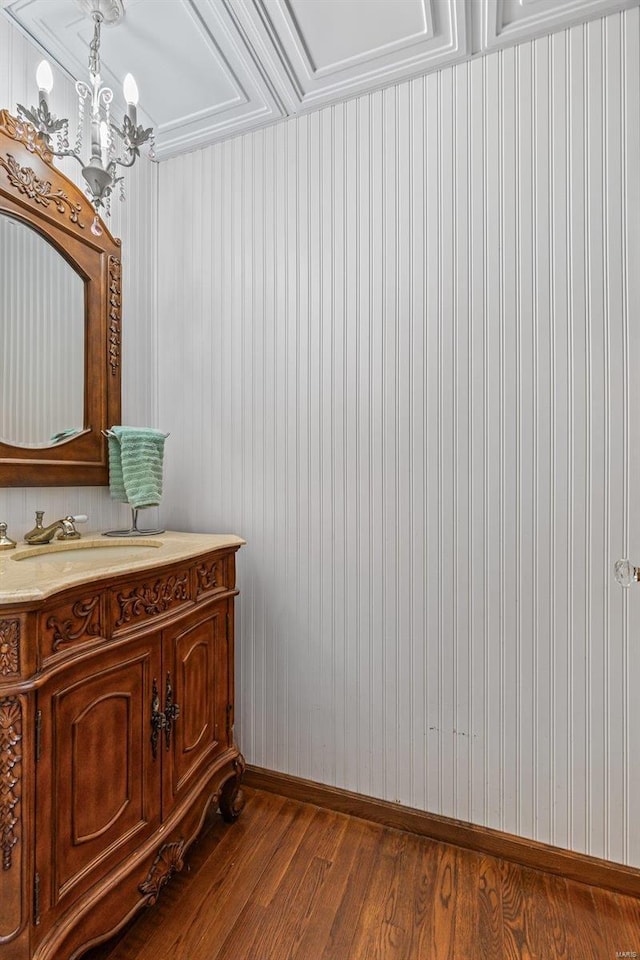 bathroom featuring a chandelier, baseboards, wood finished floors, and vanity