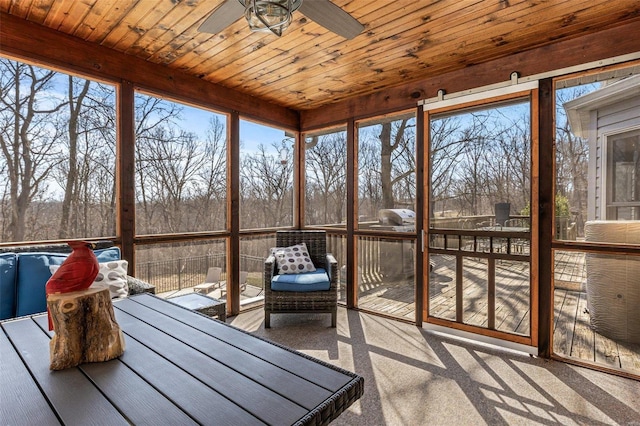 unfurnished sunroom with a ceiling fan and wood ceiling