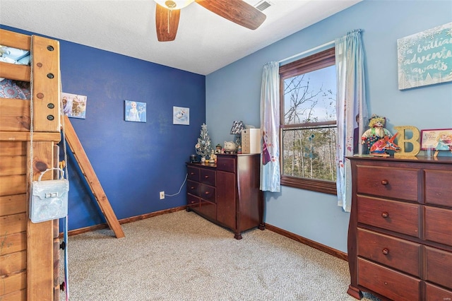 bedroom featuring a textured ceiling, light colored carpet, baseboards, and ceiling fan